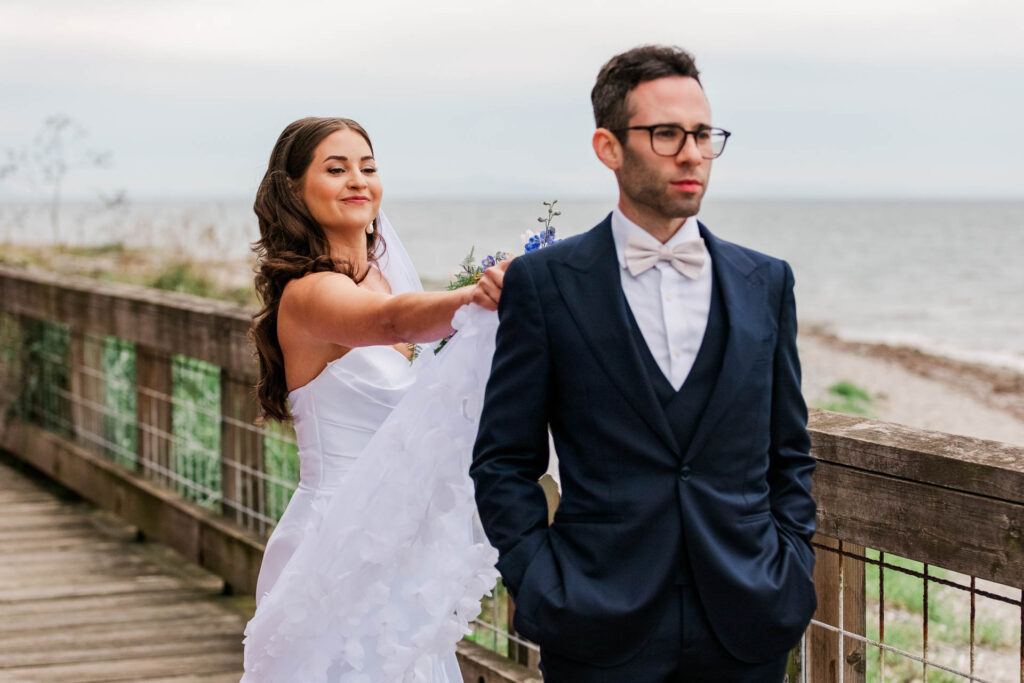 Bride tapping her groom on the shoulder for the first look. He is not facing her, but he is about to see her for the first time.